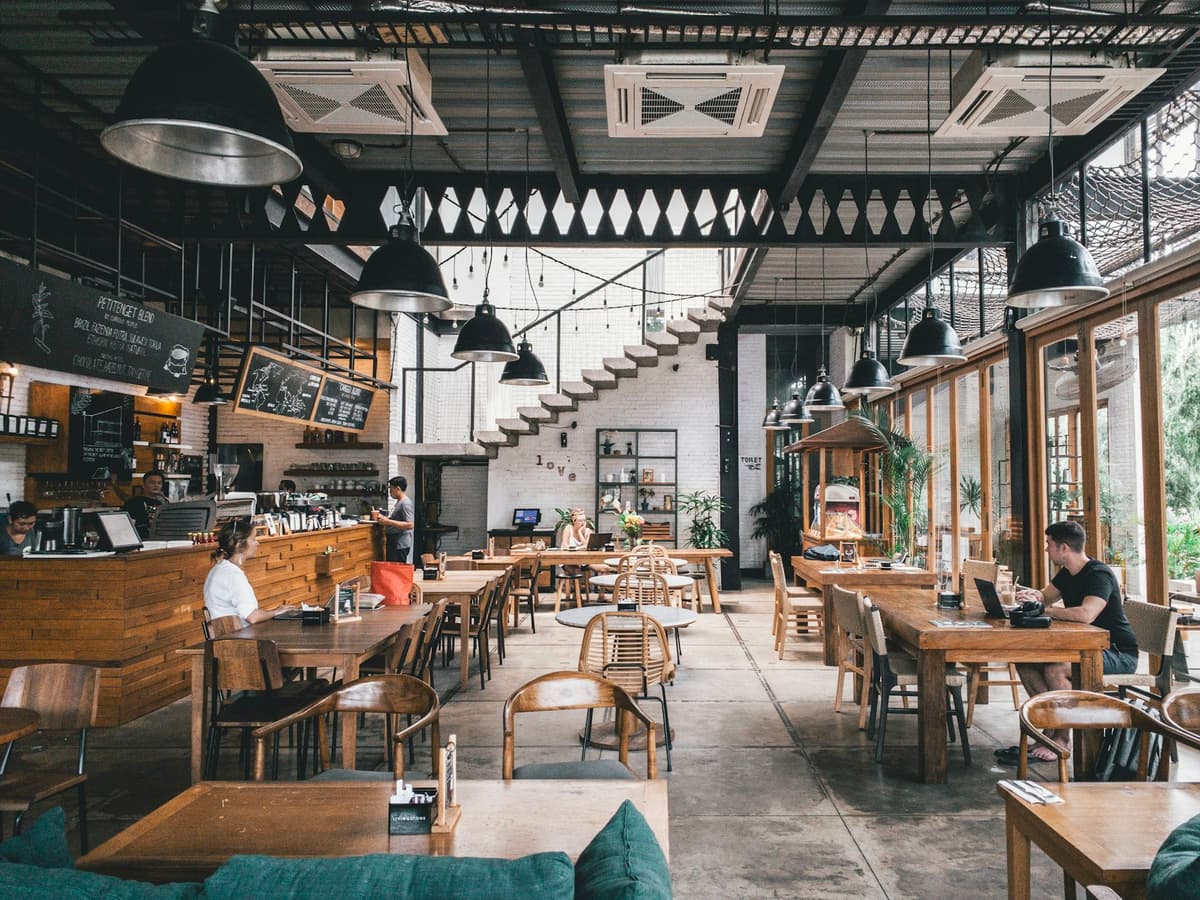 Busy neighborhood cafe with customers at wooden tables